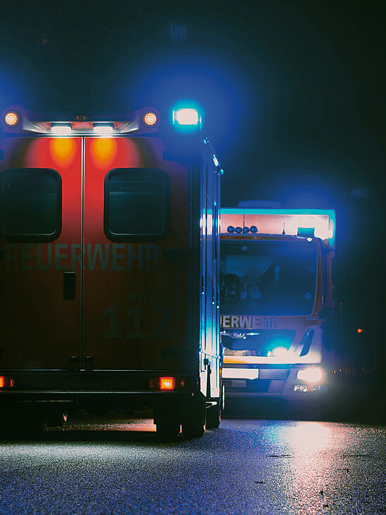 Rettungsfahrzeuge bei Nacht mit Blaulicht