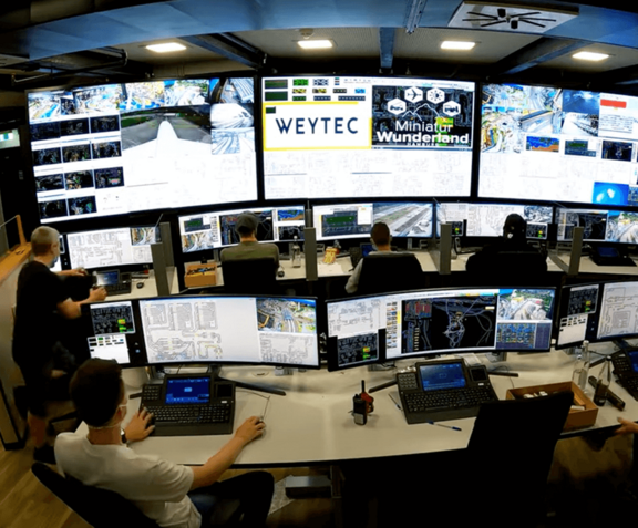 Control Room mit mehreren Arbeitsplätzen, Bildschirmen und Video Walls