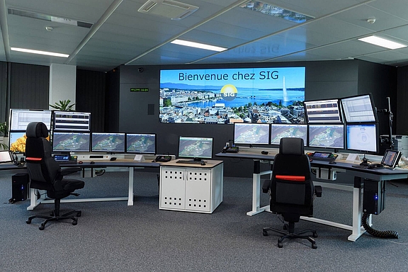Innenaufnahme eines Control Rooms mit zwei Arbeitsplätze, zwei Video Walls und zahlreichen Bildschirmen