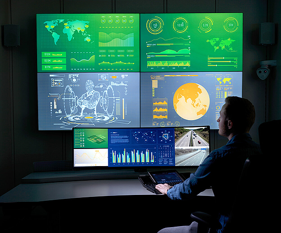  Man in control room in front of personal video wall