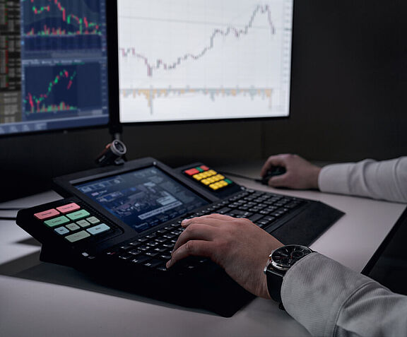 [Translate to English:] Männliche Hände bedienen WEYTEC smartTOUCH Tastatur an Trading Arbeitsplatz