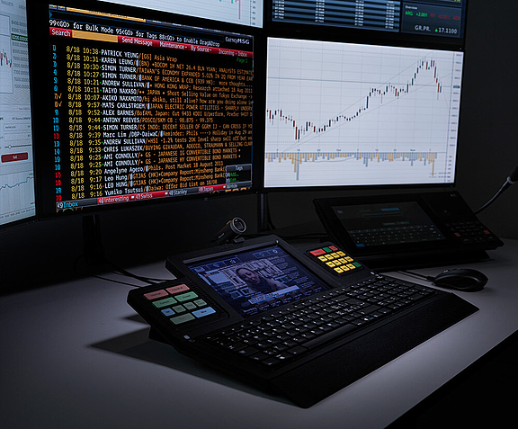 WEYTEC smartTOUCH keyboard in front of multiple screens in a trading floor environment