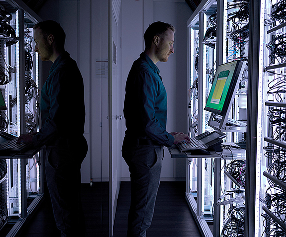 Man in lighted server room at administration workplace