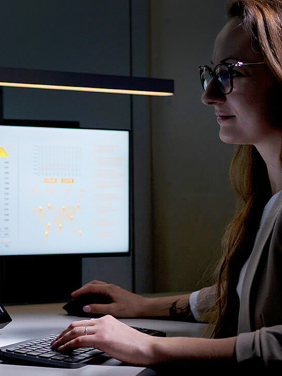  Woman in control room sitting at desk with multiple screens