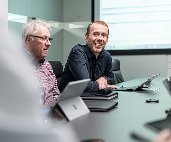 Two men with tablets having a conversation