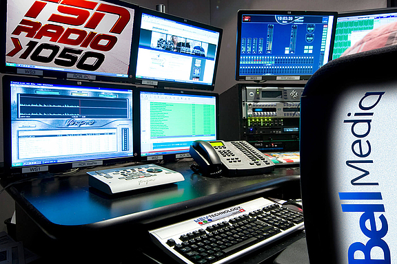 Rundfunk-Studio mit mehreren Bildschirmen und Tastaturen