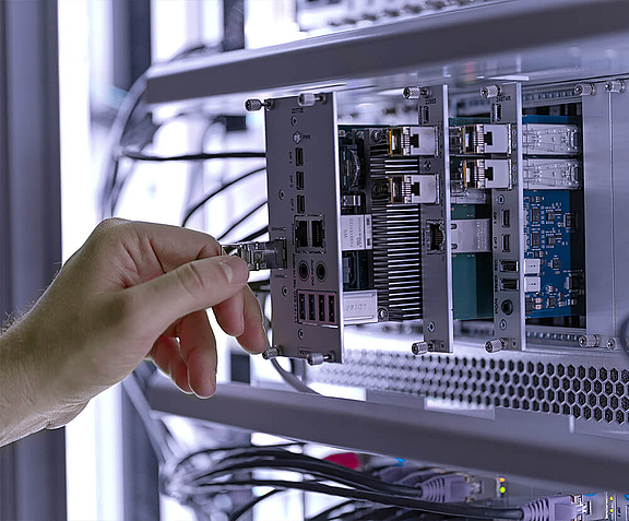 A hand plugs connections into a computer