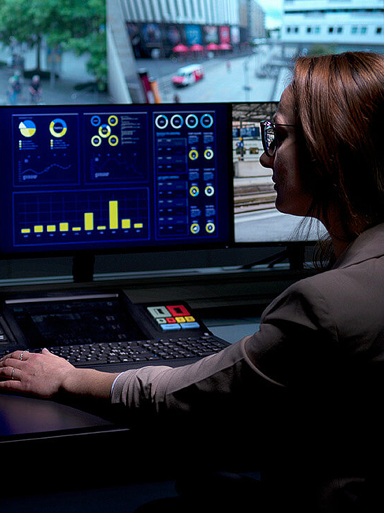 Woman working in control room on several screens