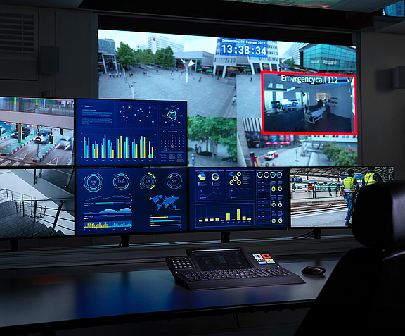 Arbeitsplatz im Control Room mit mehreren Bildschirmen und Video Walls