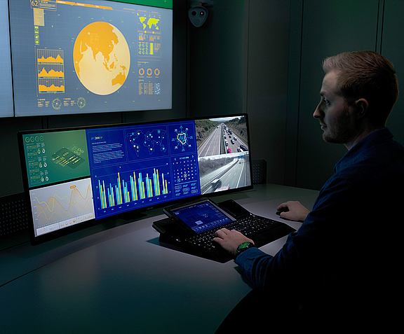 Mann im Control Room vor WEYTEC smartTOUCH Tastatur und mehreren Bildschirmen