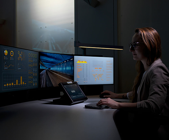 Woman in control room working on multiple screens