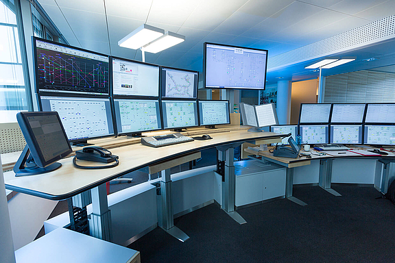 Control Center mit zwei Schreibtischen und zahlreichen Bildschirmen