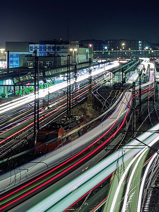 Beleuchtetes Bahnschienen-Netz bei Nacht 